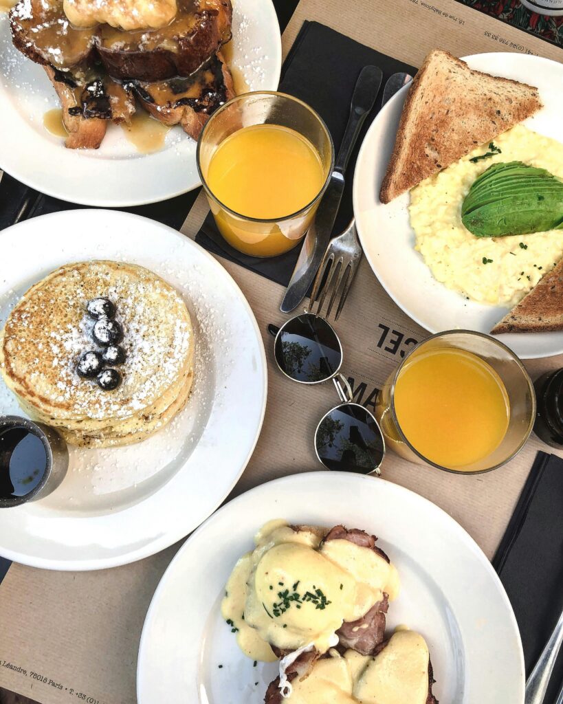 Enticing breakfast spread in Paris featuring pancakes, scrambled eggs, and fresh orange juice.